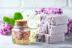 O sabão feito a mão, o frasco de vidro com óleo perfumado e o lilás florescem para termas e aromaterapia fotos de stock royalty free O sabão feito a mão, o frasco de vidro com óleo perfumado e o lilás florescem para termas e aromaterapia fotos de stock royalty free