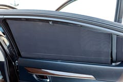 O Sunblind no vidro da porta traseira do close-up da cor do preto do carro protege da malha dobro textured dos raios do sol da foto de stock royalty free O Sunblind no vidro da porta traseira do close-up da cor do preto do carro protege da malha dobro textured dos raios do sol da foto de stock royalty free