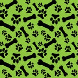 O teste padrão sem emenda com a pata do cão preto imprime e os ossos em um fundo verde ilustração do vetor O teste padrão sem emenda com a pata do cão preto imprime e os ossos em um fundo verde ilustração do vetor