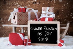 O trenó com presentes, flocos de neve, Guten Rutsch 2019 significa o ano novo imagem de stock royalty free O trenó com presentes, flocos de neve, Guten Rutsch 2019 significa o ano novo imagem de stock royalty free