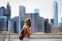 O turista fêmea aprecia a vista panorâmica com os arranha-céus de Manhattan em New York, EUA foto de stock royalty free O turista fêmea aprecia a vista panorâmica com os arranha-céus de Manhattan em New York, EUA foto de stock royalty free