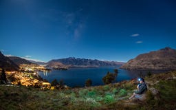 O viajante novo aprecia a cena da noite de queenstown, Nova Zelândia foto de stock O viajante novo aprecia a cena da noite de queenstown, Nova Zelândia foto de stock