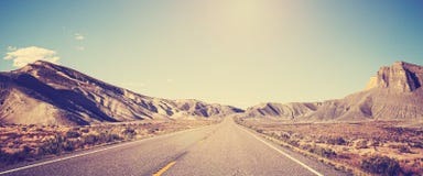 O vintage tonificou a foto panorâmico da estrada do deserto foto de stock royalty free O vintage tonificou a foto panorâmico da estrada do deserto foto de stock royalty free