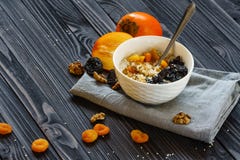 Oatmeal με Persimmon σε έναν μαύρο ξύλινο πίνακα στοκ φωτογραφία με δικαίωμα ελεύθερης χρήσης Oatmeal με Persimmon σε έναν μαύρο ξύλινο πίνακα στοκ φωτογραφία με δικαίωμα ελεύθερης χρήσης