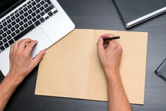 Obenliegende Ansicht des Bürotischs mit bemannt die Hände, die mit Stift O schreiben lizenzfreie stockbilder Obenliegende Ansicht des Bürotischs mit bemannt die Hände, die mit Stift O schreiben lizenzfreie stockbilder