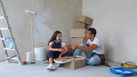 Obenliegende Ansicht von den jungen Paaren, die Pizza beim Sitzen auf Boden in der neuen Wohnung essen stock footage Obenliegende Ansicht von den jungen Paaren, die Pizza beim Sitzen auf Boden in der neuen Wohnung essen stock footage