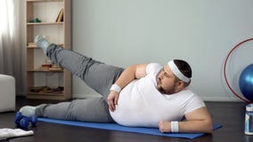 Obese male lifting leg lying on mat, healthy lifestyle, sport leisure, exercises stock photos Obese male lifting leg lying on mat, healthy lifestyle, sport leisure, exercises stock photos