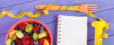 Obstsalat, Zentimeter mit Dummköpfen und Notizblock für das Schreiben von Anmerkungen, gesunder Lebensstil und Nahrungskonzept stockfotografie Obstsalat, Zentimeter mit Dummköpfen und Notizblock für das Schreiben von Anmerkungen, gesunder Lebensstil und Nahrungskonzept stockfotografie