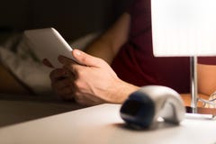 Obsługuje czytelniczą elektroniczną książkę lub używać pastylka w łóżku zdjęcia royalty free Obsługuje czytelniczą elektroniczną książkę lub używać pastylka w łóżku zdjęcia royalty free