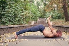 Obsługuje ćwiczy joga plenerowy w parku, natura na tle Facet z nagiej półpostaci ćwiczy asana na joga macie Zdrowy obrazy royalty free Obsługuje ćwiczy joga plenerowy w parku, natura na tle Facet z nagiej półpostaci ćwiczy asana na joga macie Zdrowy obrazy royalty free