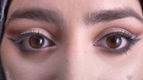 Occhio-ritratto del primo piano di bella giovane donna musulmana nel hijab con trucco che guarda nella macchina fotografica su fo archivi video Occhio-ritratto del primo piano di bella giovane donna musulmana nel hijab con trucco che guarda nella macchina fotografica su fo archivi video