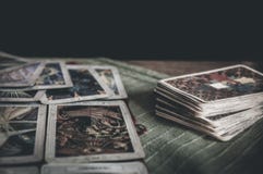Occult mystic tarot deck and old tarot cards laying on table for a magical pagan ritual psychic destiny reading