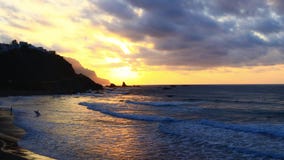 Oceano giallo di tramonto con i surfisti Oceano giallo di tramonto con i surfisti