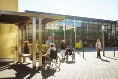 October 2018. Germany, Helios Klinikum Krefeld. A group of pensioners in wheel chairs rests on a square, in a park near the entran royalty free stock photography October 2018. Germany, Helios Klinikum Krefeld. A group of pensioners in wheel chairs rests on a square, in a park near the entran royalty free stock photography