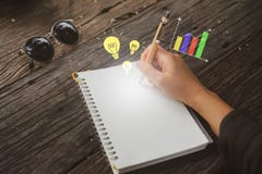 Odbitkowa przestrzeń pisze puszku w białym notatniku z pomysłu i wykresu ikoną kobiety ręka zdjęcie royalty free Odbitkowa przestrzeń pisze puszku w białym notatniku z pomysłu i wykresu ikoną kobiety ręka zdjęcie royalty free