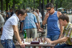 ODESSA UKRAINA - AUGUSTI 14, 2015: Unga män som spelar schack i en parkera av Odessa, Ukraina arkivbilder ODESSA UKRAINA - AUGUSTI 14, 2015: Unga män som spelar schack i en parkera av Odessa, Ukraina arkivbilder