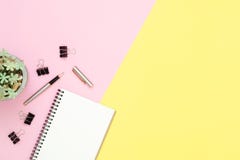 Odgórnego widoku biurowy biurko z otwartym egzaminem próbnym w górę notatników, ołówek i roślina na różowym żółtym pastelowego ko obrazy stock Odgórnego widoku biurowy biurko z otwartym egzaminem próbnym w górę notatników, ołówek i roślina na różowym żółtym pastelowego ko obrazy stock