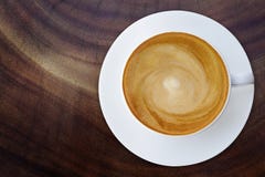 Odgórny widok gorąca kawowa cappuccino filiżanka z spodeczkiem na drewnianym textur zdjęcie royalty free Odgórny widok gorąca kawowa cappuccino filiżanka z spodeczkiem na drewnianym textur zdjęcie royalty free