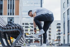 Odległy plan mężczyzna kładzenie na jego białej pozyci ławce i sneakers następnie zdjęcie stock Odległy plan mężczyzna kładzenie na jego białej pozyci ławce i sneakers następnie zdjęcie stock