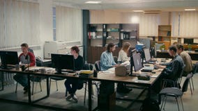 Office People are Working Together at their Computers on a Desk