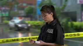Oficial de policía americano asiático en la escena del crimen metrajes Oficial de policía americano asiático en la escena del crimen metrajes