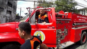 Oficial del fuego en el coche de bomberos que da órdenes Oficial del fuego en el coche de bomberos que da órdenes