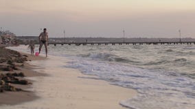Ojca i syna bieg wzdłuż plaży z piłką zbiory Ojca i syna bieg wzdłuż plaży z piłką zbiory