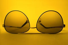 Okulary przeciwsłoneczni na żółtym tle obrazy stock Okulary przeciwsłoneczni na żółtym tle obrazy stock