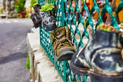 Old battered boots with lace on fence Stock Photo Old battered boots with lace on fence Stock Photo