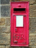 Old British Red post box set in a stone wall with keyhole Stock Photos Old British Red post box set in a stone wall with keyhole Stock Photos