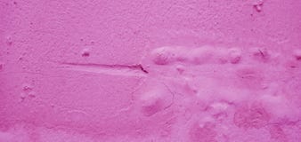 Old concrete walls have paint stains and rough surface marks. The surface is dark pink for the background.