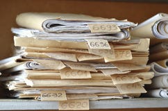 Old documents, drawings with numbers stacked on shelves in the o