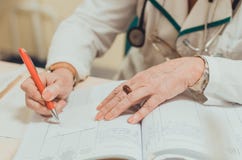 Old female experienced doctor writing a medical prescription royalty free stock photography Old female experienced doctor writing a medical prescription royalty free stock photography