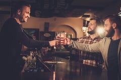 Old friends having fun and drinking draft beer at bar counter in pub. royalty free stock images Old friends having fun and drinking draft beer at bar counter in pub. royalty free stock images