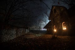 Old House With A Ghost In The Forest At Night Or Abandoned Haunted Horror House In Fog. Old Mystic Building In Dead Tree Forest. Royalty Free Stock Photography