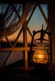 Old Lantern In An Old Window With A View Of The Sunset In The Field. Dark Photo. Royalty Free Stock Photography