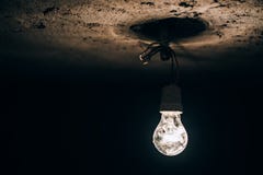 Old Light Bulb Glowing In The Dark Basement. Electricity Improvisation At Construction Site. Stock Image Old Light Bulb Glowing In The Dark Basement. Electricity Improvisation At Construction Site. Stock Image
