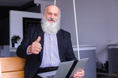 Old retired man uses laptop and communicates with colleagues beh stock photography Old retired man uses laptop and communicates with colleagues beh stock photography