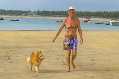 Old Man Walking Forward with his Dog at Beach royalty free stock images Old Man Walking Forward with his Dog at Beach royalty free stock images