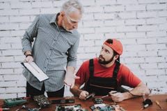 Old Manager Checking Motherboard near Worker. royalty free stock image Old Manager Checking Motherboard near Worker. royalty free stock image