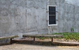 An old rustic alley wall with one solitary barred window. stock images An old rustic alley wall with one solitary barred window. stock images