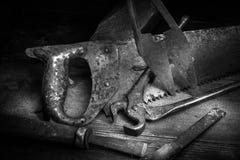 Old rusty tool in the dark room, totally dark place, playing with lights, old stuff, vice, keys on wooden table royalty free stock photo Old rusty tool in the dark room, totally dark place, playing with lights, old stuff, vice, keys on wooden table royalty free stock photo