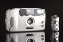 Old scratched automatic photocamera isolated on the black background with reflection stock image Old scratched automatic photocamera isolated on the black background with reflection stock image