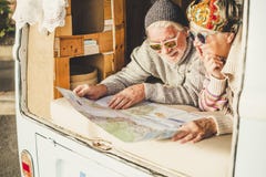 Old Senior Couple Enjoy The Travel Vacation Planning Lay Down Inside A Vintage Van - Happy Lifestyle For Retired People Enjoying Royalty Free Stock Images