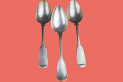 Old spoons on a living coral background. Color of the year 2019 living coral. Top view. Free space for text royalty free stock images Old spoons on a living coral background. Color of the year 2019 living coral. Top view. Free space for text royalty free stock images