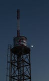 Old water tank with antenna and graffiti in front of the moon royalty free stock photos Old water tank with antenna and graffiti in front of the moon royalty free stock photos