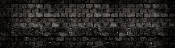 Old weathered grungy black dark concrete block brick wall texture background abandoned house holes cracks wide banner background