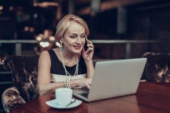 Old Woman looking Laptop and talking on Phone stock image Old Woman looking Laptop and talking on Phone stock image