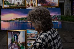 Old Woman Looking at Paintings royalty free stock images Old Woman Looking at Paintings royalty free stock images