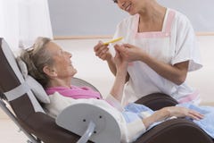 Older senior woman receiving home beauty treatment hand'scare stock images Older senior woman receiving home beauty treatment hand'scare stock images